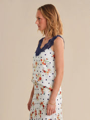 Woman wearing a floral dress with lace trim on a beige background