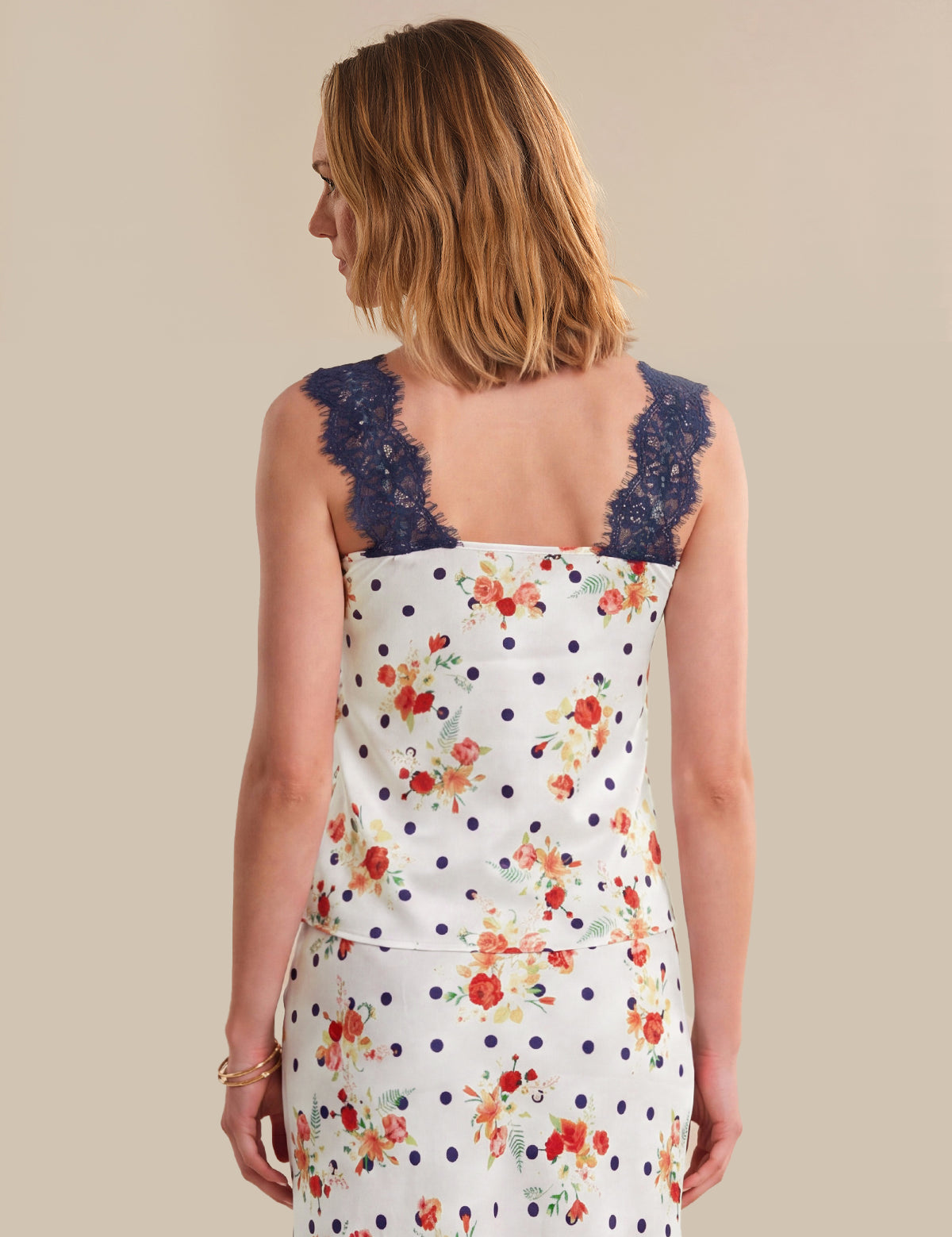 Woman wearing a floral dress with a lace neckline on a beige background