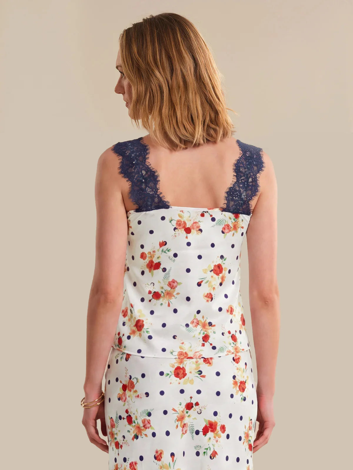 Woman wearing a floral dress with a lace neckline on a beige background