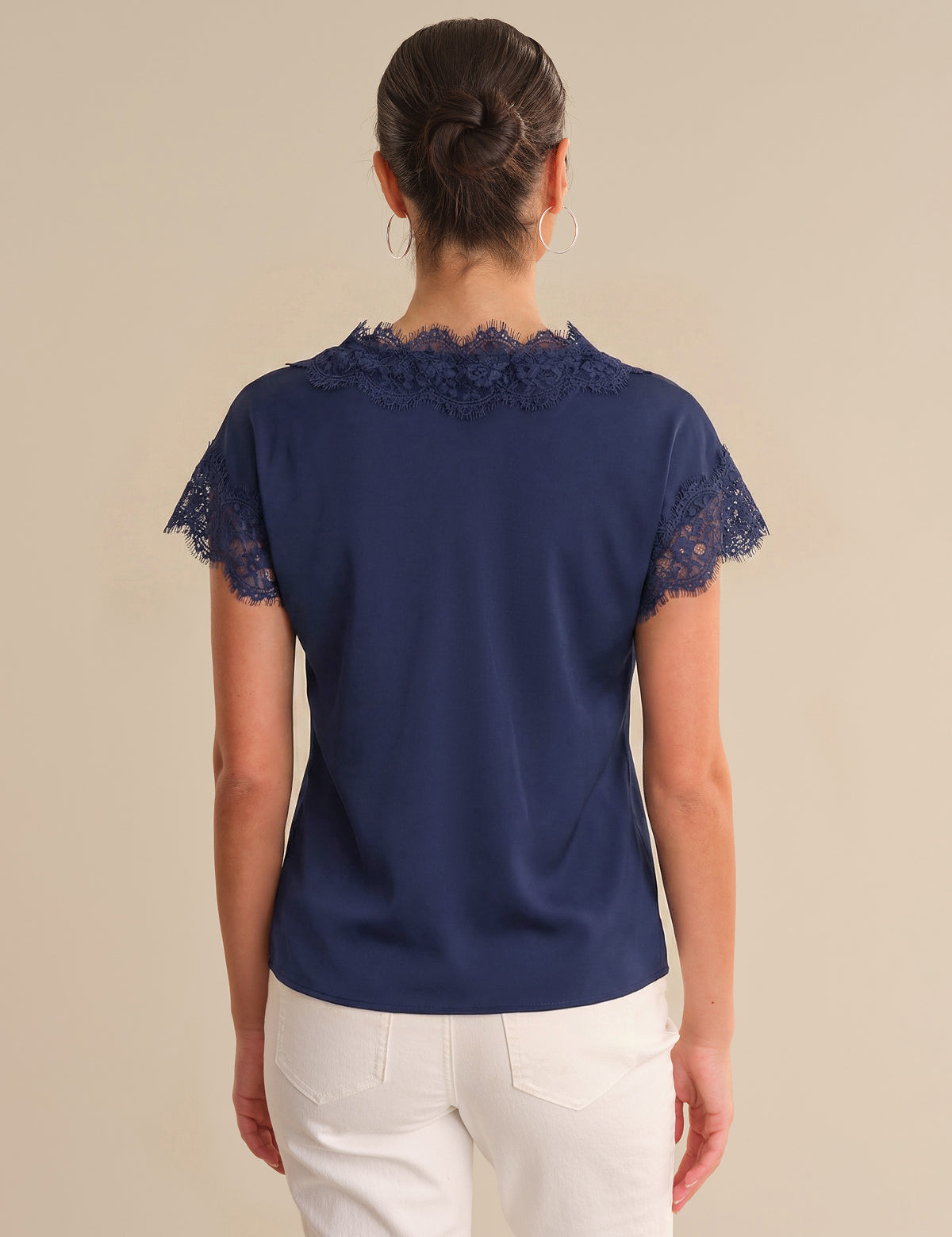 Navy blue blouse with lace details on a beige background