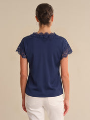 Navy blue blouse with lace details on a beige background