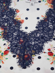 Navy lace collar on a white fabric with floral and polka dot patterns