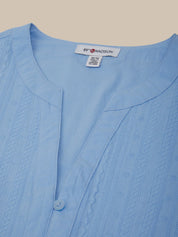 Close-up of a light blue garment with a brand label on a beige background