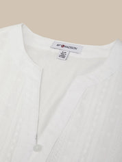 White blouse with a visible brand label on a beige background