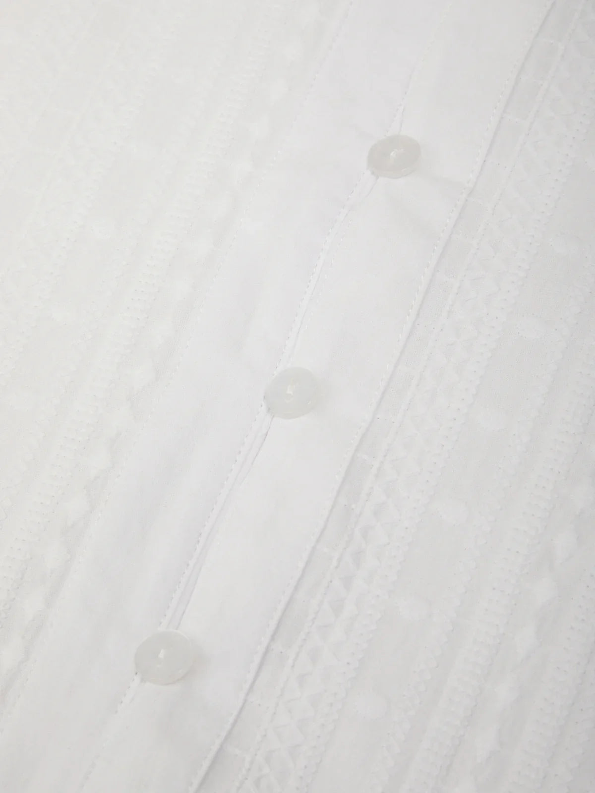 Close-up of a white shirt with buttons on a white background
