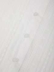 Close-up of a white shirt with buttons on a white background