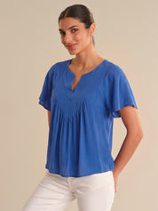 Woman wearing a blue blouse with a beige background