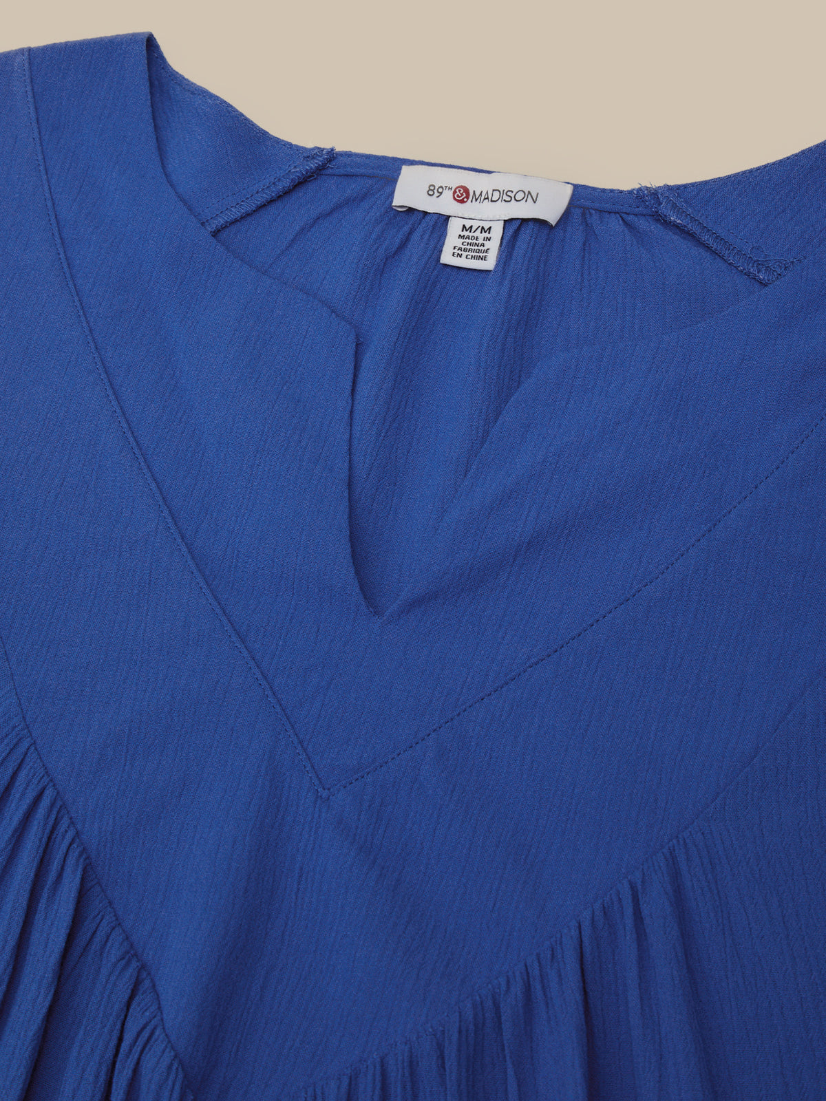 Blue dress with a brand label on a beige background