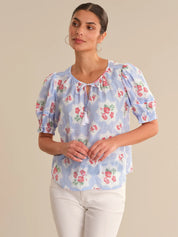 Woman wearing a floral blouse with a beige background