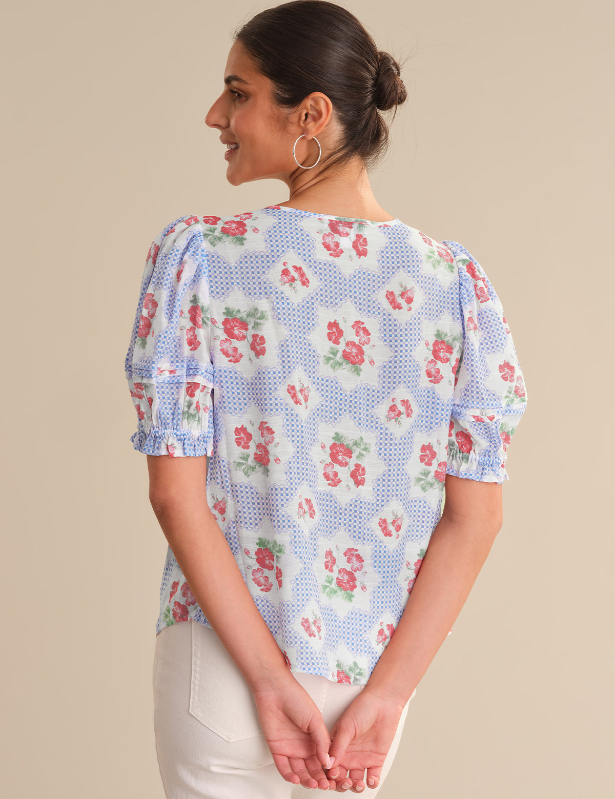 Woman wearing a floral blouse with a beige background