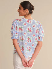 Woman wearing a floral blouse with a beige background