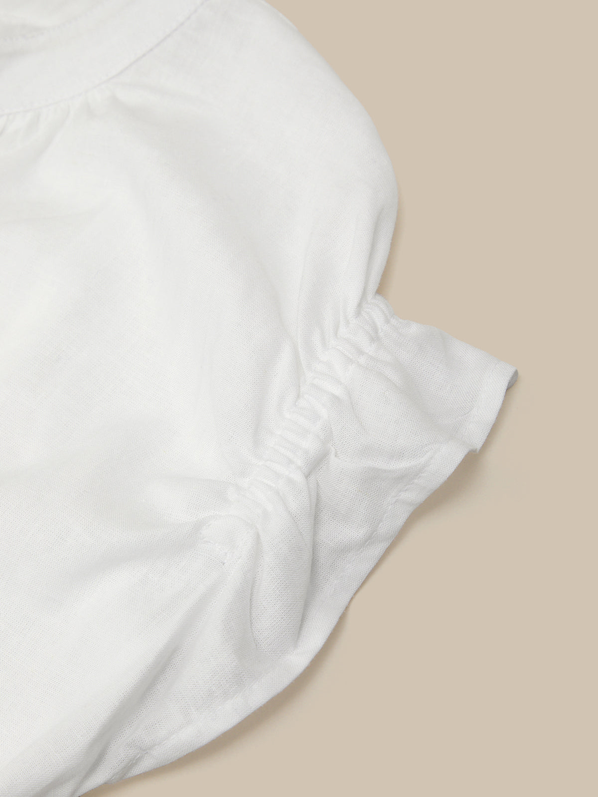 White strapless top on a beige background