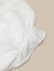 White strapless top on a beige background