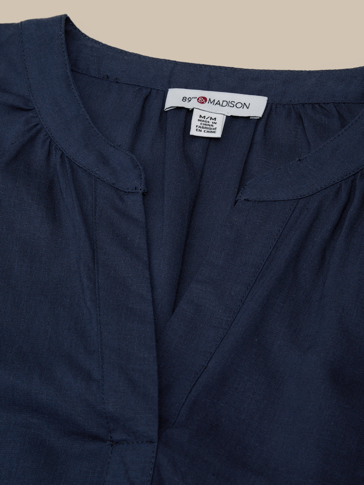 Navy blue garment with '89th Madison' label on a beige background