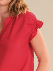 Red blouse worn by a person on a neutral background