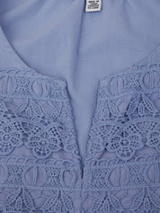 Close-up of a light blue blouse with lace detailing on the neckline.