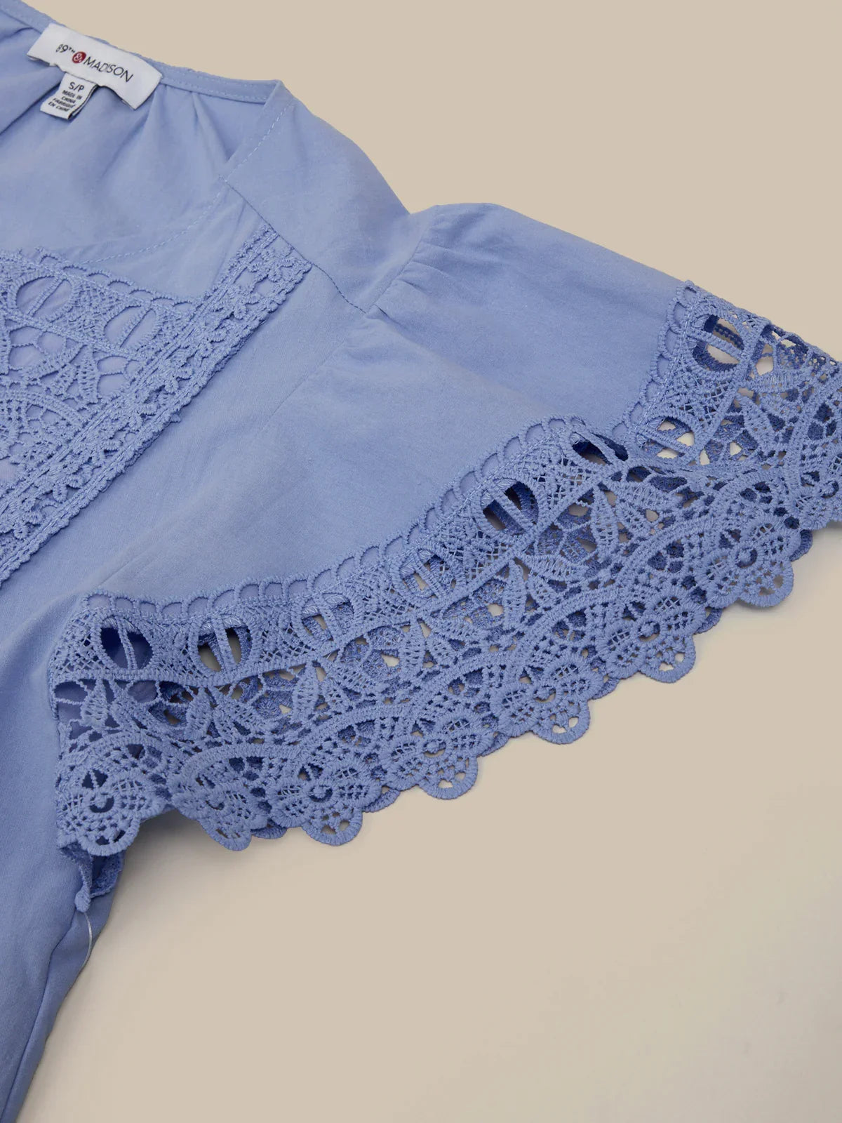 Blue lace-trimmed garment on a beige background