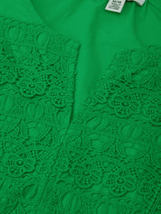 Green lace top with a tag on a green background