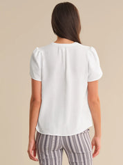 Woman wearing a white top and striped pants on a beige background