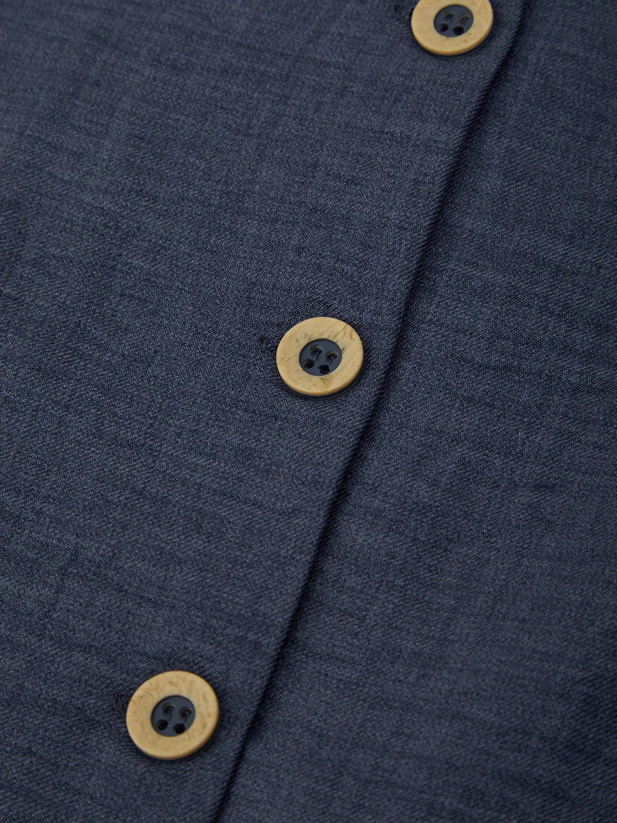 Close-up of a navy blue fabric with wooden buttons