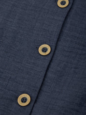 Close-up of a navy blue fabric with wooden buttons