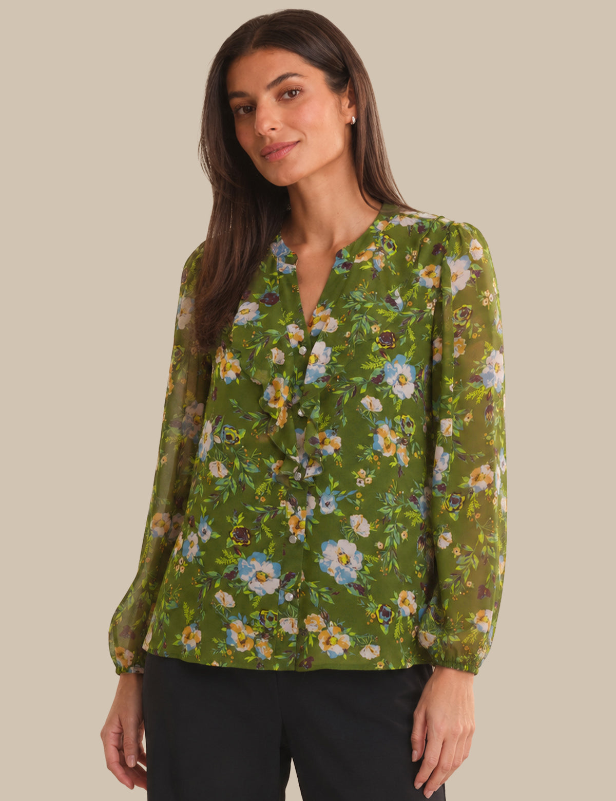 Woman wearing a green floral blouse against a beige background
