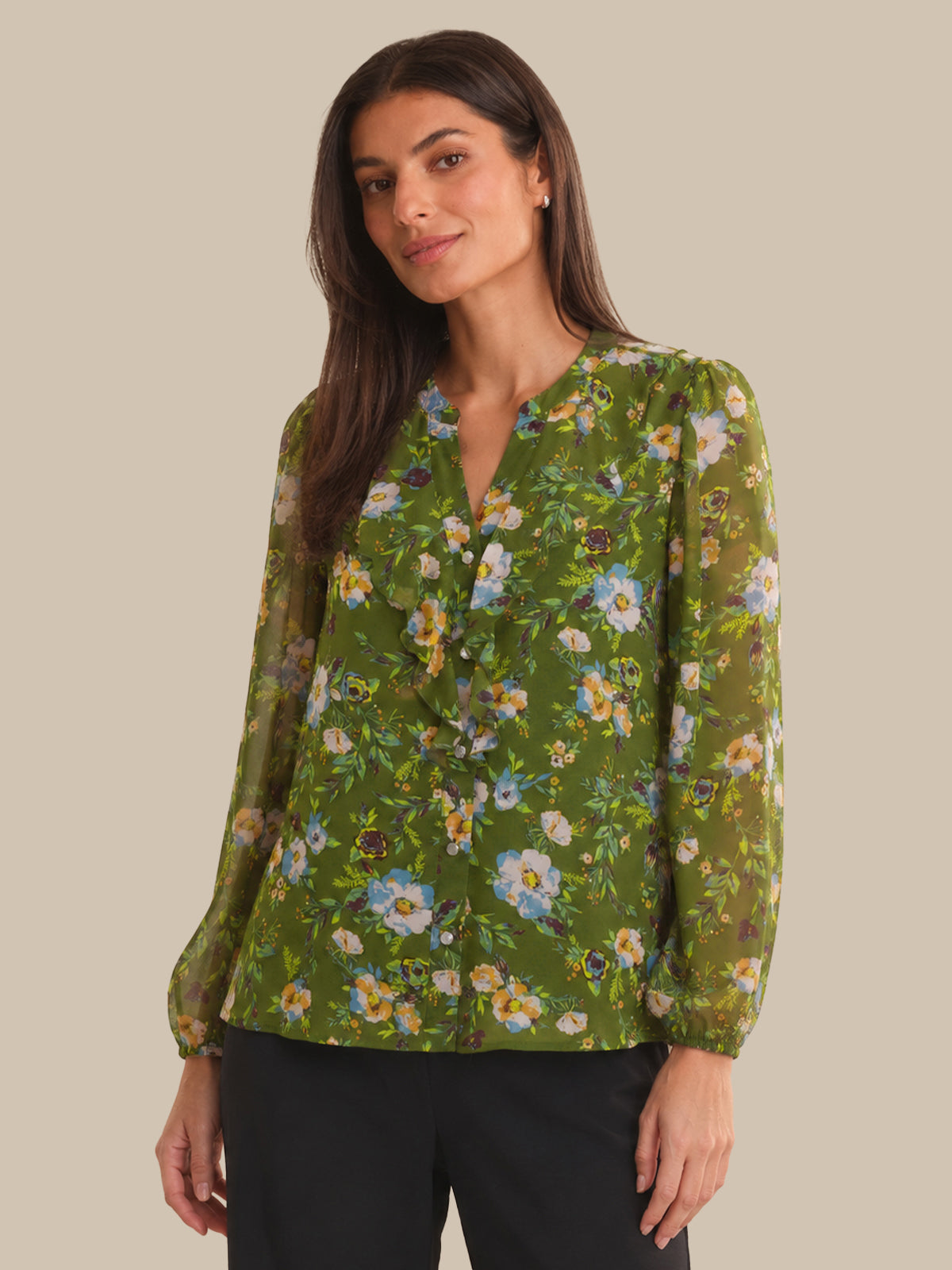 Woman wearing a green floral blouse against a beige background