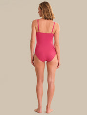 Woman wearing a pink swimsuit on a beige background