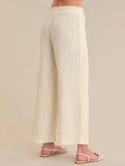 Beige wide-leg pants worn by a person on a plain background