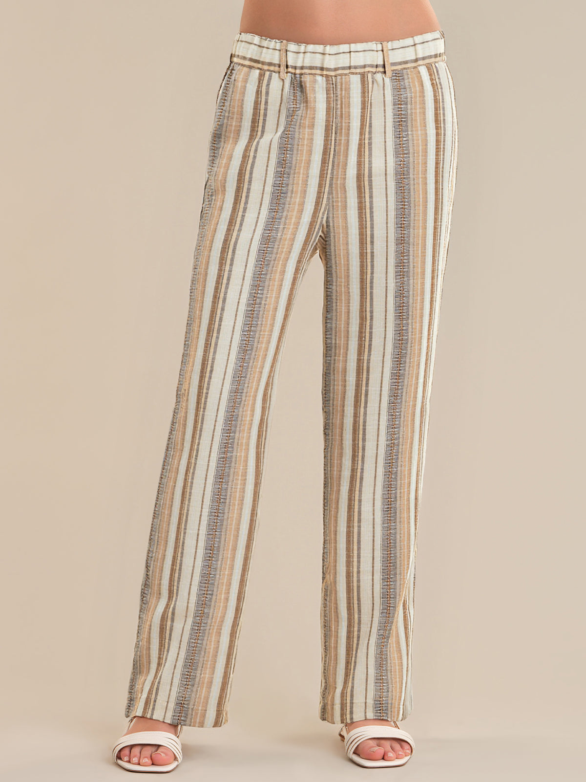 Striped pants worn by a person on a beige background