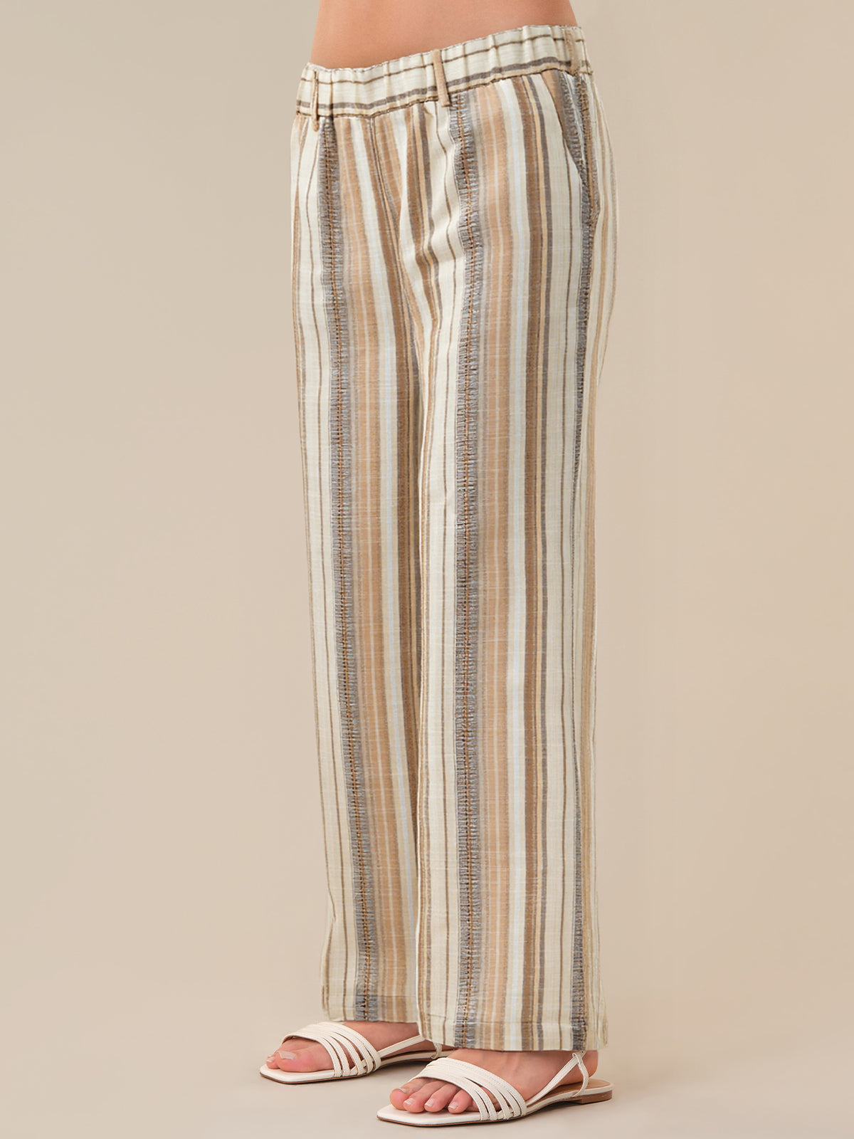 Striped pants worn by a person on a beige background