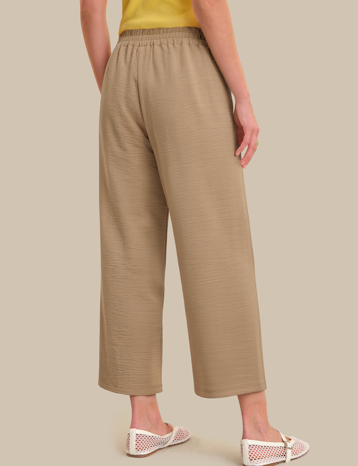 Beige pants worn by a person on a beige background