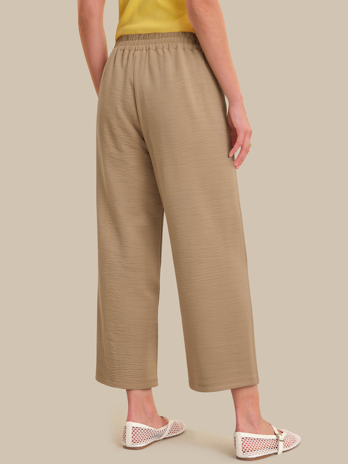 Beige pants worn by a person on a beige background