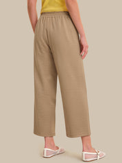 Beige pants worn by a person on a beige background