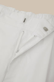 Close-up of a white jacket with zippers on a beige background