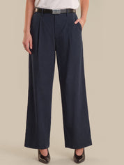 Person wearing navy wide-leg pants on a beige background