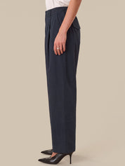 Navy blue pants worn by a person on a beige background