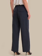 Navy blue wide-leg pants worn by a person on a beige background