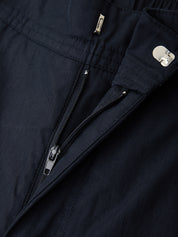 Close-up of a navy blue jacket with zippers and buttons.