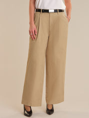Person wearing beige wide-leg pants on a plain background