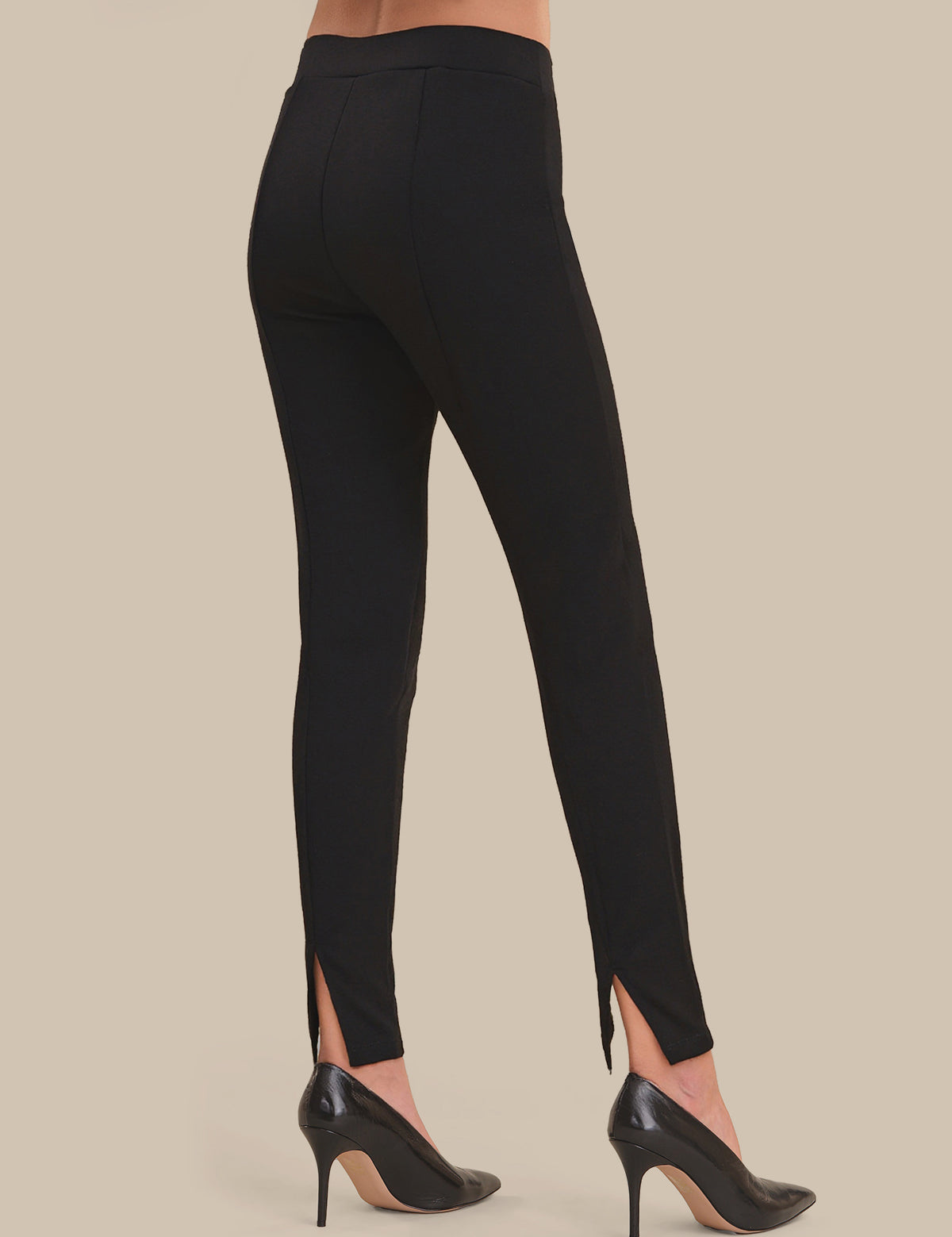 Black pants with a high slit on a beige background