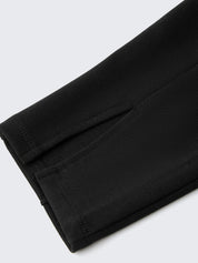 Folded black pants on a light gray background