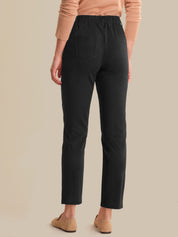 Person wearing black pants and tan shoes on a beige background