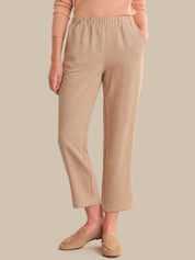 Person wearing beige pants and a matching top against a neutral background