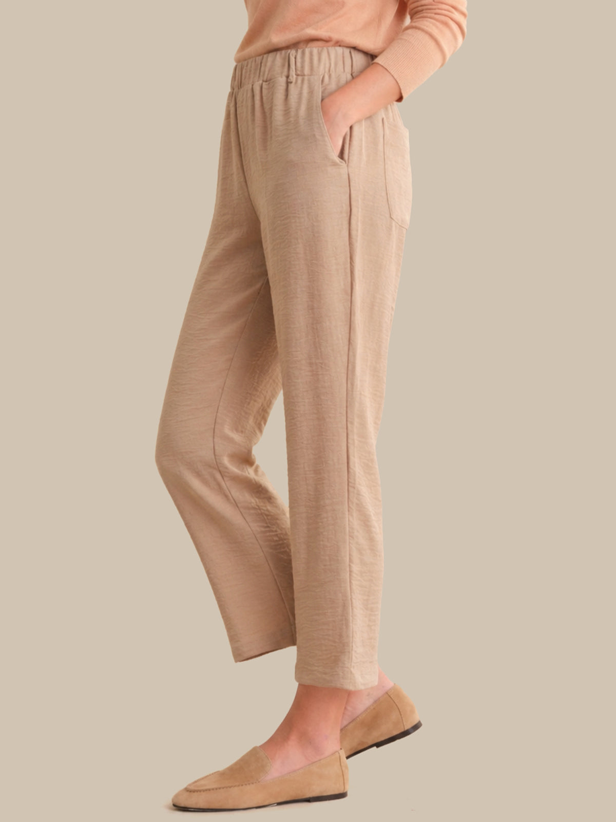 Beige pants worn by a person on a beige background