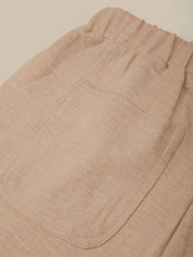 Close-up of beige pants with a pocket on a beige background