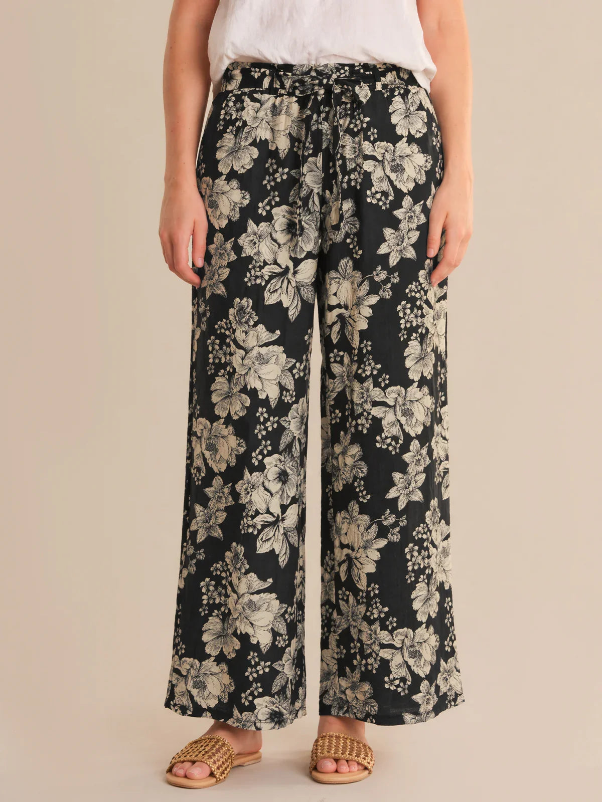 Floral-patterned pants worn by a person on a beige background