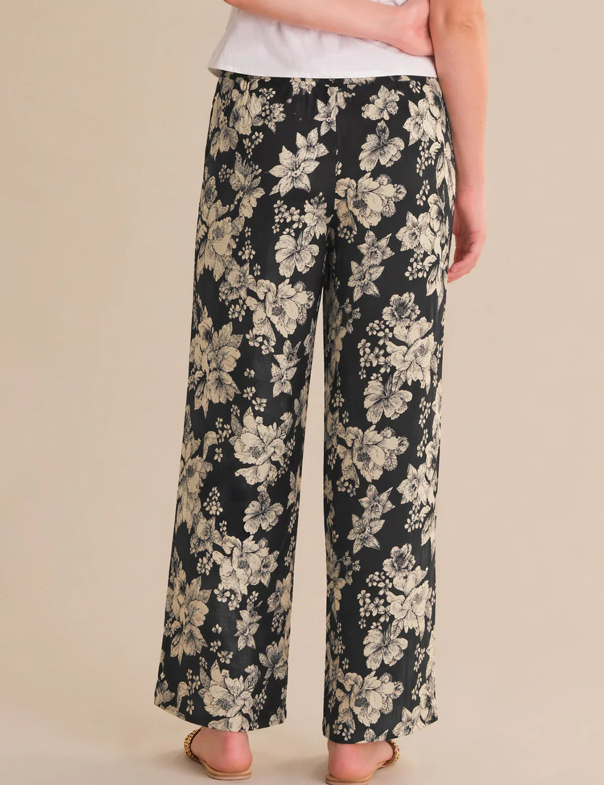 Floral-patterned pants worn by a person on a beige background