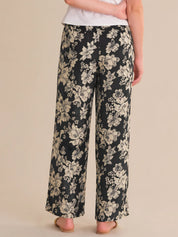 Floral-patterned pants worn by a person on a beige background