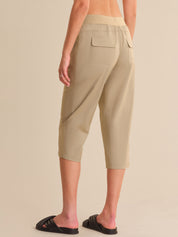 Beige capri pants worn by a person on a beige background